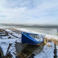 Blue boat on the shore of the frozen sea Royalty Free Stock Photo