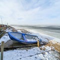 Blue boat on the shore of the frozen sea Royalty Free Stock Photo