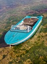 Blue boat tied up in shallow sea Royalty Free Stock Photo