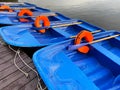 Blue boats with oars and orange lifebuoys