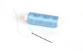 Blue bobbin of thread with needle on white Royalty Free Stock Photo