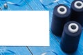 Blue bobbin thread and paper sheet on table. Copy space Royalty Free Stock Photo