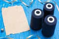 Blue bobbin thread and vintage paper on table. Copy space Royalty Free Stock Photo