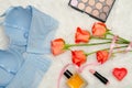 Blue bodice with lace, inside view. White fur, orange roses and cosmetics. Fashionable concept. Top view