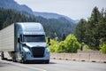 Blue bonnet big rig semi truck with black grille transporting cargo in refrigerator semi trailer running on the highway road with Royalty Free Stock Photo