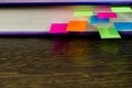 A blue book with colored bookmarks on a wooden table