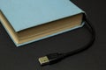 Blue book with an USB connector on a black background Royalty Free Stock Photo