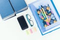 Blue books background, smartphone, notebook, glasses and pens on white wooden table in office for education learning concept Royalty Free Stock Photo