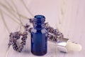Blue bottle of lavender massage oil on lavender wooden background Royalty Free Stock Photo