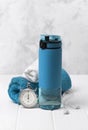 Blue bottle of water, towels, headphones and stopwatch. Sports equipment on white wooden background Royalty Free Stock Photo