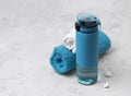 Blue bottle of water and towels. Sports equipment on gray concrete background Royalty Free Stock Photo