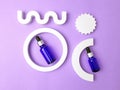 Blue bottles with a pipette on a lilac background. Royalty Free Stock Photo
