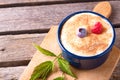 Blue bowl full of creamy dessert and with couple of berries Royalty Free Stock Photo