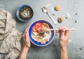 Blue bowl with healthy vegetarian breakfast ingredients in woman`s hands Royalty Free Stock Photo