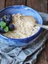 Blue bowl with oatmeal porridge and blueberry.