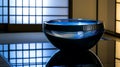 A blue bowl with water in it sits on a table Royalty Free Stock Photo