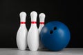 Blue bowling ball and pins on grey marble table