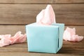 Blue box with paper tissues and used crumpled napkins on grey wooden background Royalty Free Stock Photo