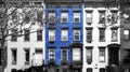 Blue brick building isolated against row of old black and white buildings in Manhattan New York City Royalty Free Stock Photo