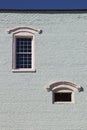 Blue brick building side with white arched windows