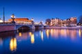 Blue bridge, Amsterdam, Netherlands. Blauwbrug. Evening cityscape. Blue sky and city lights. Dutch canals. Royalty Free Stock Photo