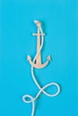 Blue background with handmade paper anchor and rope Royalty Free Stock Photo