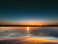 Blue bright starry sky on pink yellow sunset at sea water vawe reflection blurred light full moon moonlight  skyline  nebula natur Royalty Free Stock Photo