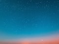 Blue bright starry sky on pink yellow sunset at sea water vawe reflection blurred light full moon moonlight  skyline  nebula natur Royalty Free Stock Photo