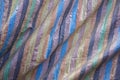 A blue brown black yellow green and pink stripes on the rough fabric with folds. rough surface texture. blue brown black yellow gr Royalty Free Stock Photo