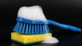 Blue brush and yellow sponge with soap bubbles Royalty Free Stock Photo