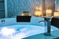 Blue bubbling Water in Spa Jacuzzi close-up faucet decorated with candles on the background, Relax and Lifestyle Royalty Free Stock Photo