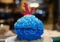 Blue buttercream cake with red anchor in front of cake-store Royalty Free Stock Photo