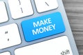 Blue button with make money words on the keyboard close-up