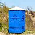Blue Cabine Of Chemical Toilet In Mountain Park at sunny Summer Day