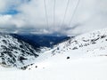 Blue cable cars flying over ski slope mountains Eastern Pyrenees, Andorra, sunny winter day Royalty Free Stock Photo