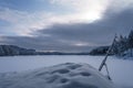 Blue calm winter landscape of a frozen lake and cloudy sky in Repovesi National Park, Finland Royalty Free Stock Photo