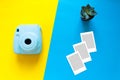 Blue camera with blank picture frames on colourful background. Fashion Film Camera. Nostalgia photography. Top view. Minimal and m