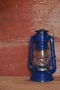 A blue camping lantern on red barn board Royalty Free Stock Photo