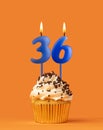 Blue candle number 36 - Birthday cupcake on orange background