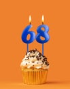 Blue candle number 68 - Birthday cupcake on orange background