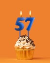 Blue birthday candle and cupcake - Number 57