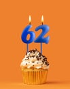Blue candle number 62 - Birthday cupcake on orange background