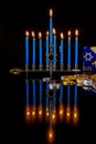 Blue candles on menorah with chocolate cions for Hanukkah jewish holiday