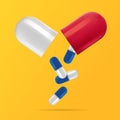 Blue capsules fall from an open red capsule Royalty Free Stock Photo