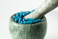 Blue capsules and orange pills with mortar pestles on white background. Royalty Free Stock Photo