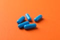 Blue capsules pills on orange background Royalty Free Stock Photo