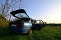 A blue car on a background of a rustic landscape with a wild cane field and a small lake. The family came to rest on the nature n Royalty Free Stock Photo