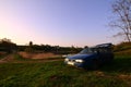 A blue car on a background of a rustic landscape with a wild cane field and a small lake. The family came to rest on the nature n Royalty Free Stock Photo