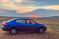 Blue car in a beautiful sunset landscape Royalty Free Stock Photo