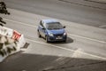 Blue car Chevrolet Aveo is driving off motorway on street. Aerial front side view of compact hatchback